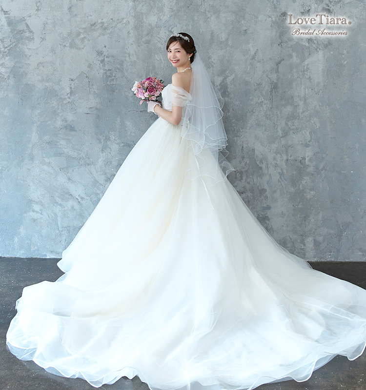 低めシニヨンヘアとネックレスで合わせた女性のイメージ